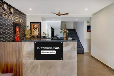 a lobby of a house with a sign on the counter at Super Townhouse Oak Sri Mahadeshwara Convention Centre Formerly Shri Aprameya Resort in Mysore