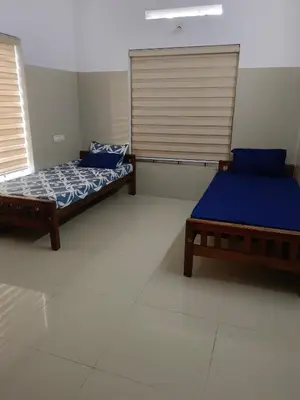 two beds sitting next to each other in a room at Kerala Ayurveda and yoga for women sn in Ernakulam