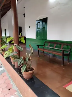 a group of potted plants in a room with a bench at Pariyarathu veedu, 4 Bed Hostel in Wayanad