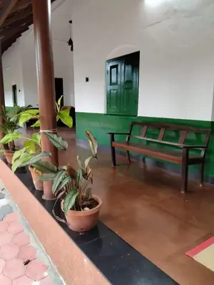 a group of potted plants and a bench in a building at Pariyarathu veedu, 4 Bed Hostel in Wayanad