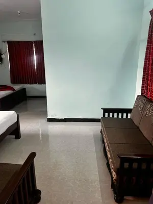 a living room with a couch and a large screen at The Wild House in Kotagiri