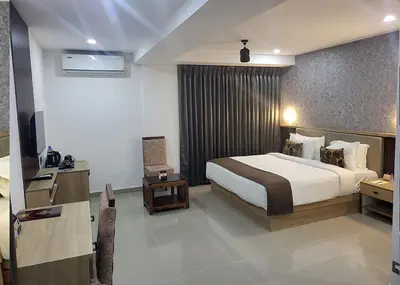 a hotel room with a bed and a television at Hotel Queen Maria in Kizhillam