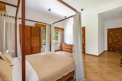 a bedroom with a bed with a canopy at Punya Farms - Luxury 5BR near Isha Yoga in Alāndurai