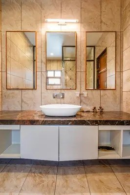 a bathroom with a sink and two mirrors at Punya Farms - Luxury 5BR near Isha Yoga in Alāndurai