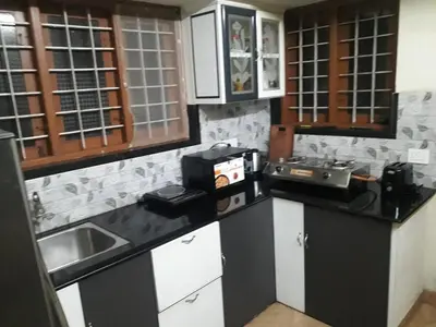 a kitchen with black and white counters and a sink at Peaceful Vacation Home Near the City in Cochin