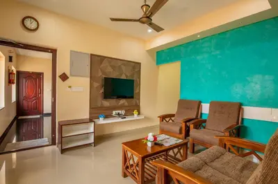 a living room with a couch and a tv at MK Residency in Coimbatore