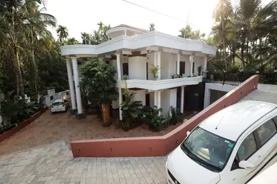 a white car parked in front of a house at Sreedevi Gardens in Irikkūr