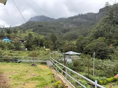a view of a hill with mountains in the background at Munnar Mountain view cottage in Munnar