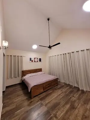 a bedroom with a bed and a ceiling fan at The Ark Haven Ooty by Scenic Serenity Stays in Ketti