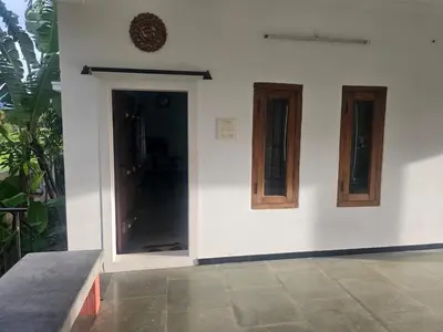 a white wall with a door and two windows at Shiva Shambo Home Stay - Entire Villa in Coimbatore