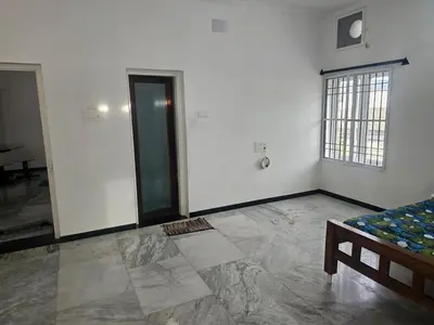 a white room with a bed and a window at Shiva Shambo Home Stay - Entire Villa in Coimbatore