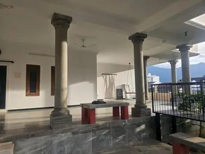 a room with columns and a bench on a patio at Shiva Shambo Home Stay - Entire Villa in Coimbatore