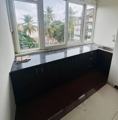 a kitchen with three windows and a counter with a sink at Fully furnished 2BHK apartment near Gokulam in Mysore