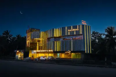 a large building with a hotel at night at Dubai Frame Residency And Hotel in Thottada
