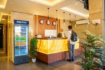 a man and a woman standing at the counter of a soda shop at Dubai Frame Residency And Hotel in Thottada