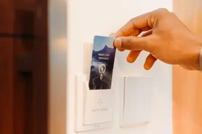 a person holding a card in a light switch at Dubai Frame Residency And Hotel in Thottada