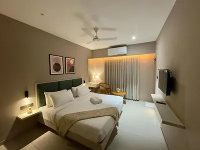 a bedroom with a large bed and a television at Altin Stays in Coimbatore