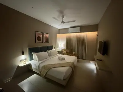 a bedroom with a large bed and a television at Altin Stays in Coimbatore