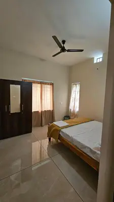 a bedroom with a bed and a ceiling fan at NAMERA Serviced Apartments in Gonikoppal