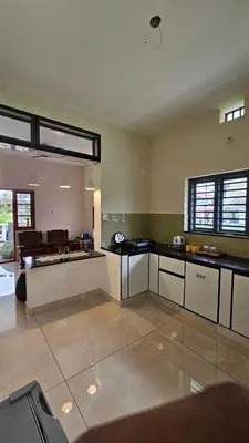 a large kitchen with black counter tops in a room at NAMERA Serviced Apartments in Gonikoppal