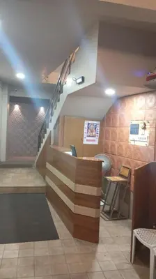 a lobby with a staircase in a restaurant at Hotel Maharajas in Kāmānayakkanpālaiyam
