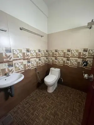 a bathroom with a toilet and a sink at SREE CHAKRA Tourist Home Guruvayoor in Guruvāyūr