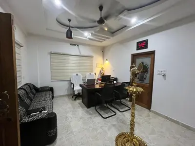 a living room with a desk and a couch at SREE CHAKRA Tourist Home Guruvayoor in Guruvāyūr