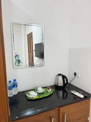 a black counter with a mirror on the wall at SREE CHAKRA Tourist Home Guruvayoor in Guruvāyūr