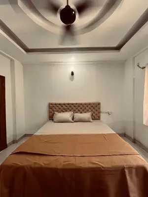 a bedroom with a large bed with a ceiling at SREE CHAKRA Tourist Home Guruvayoor in Guruvāyūr