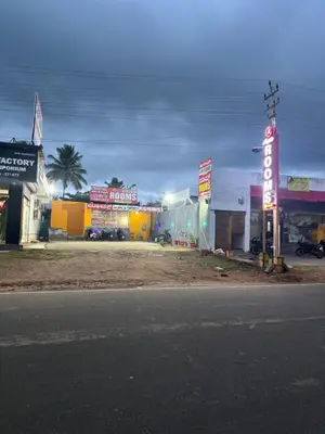 a group of shops with signs on the side of the road at Aryas comforts near Gumbaz in Shrīrangapattana