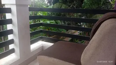 a chair sitting on a balcony with a view at Mannath Home stay in Alwaye