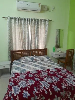 a bedroom with a bed with a red and white blanket at Mannath Home Stay in Alwaye