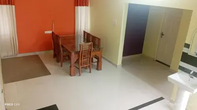 a dining room with a table and chairs and a sink at Mannath Home Stay in Alwaye