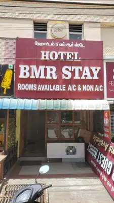 a building with a sign for a hotel blr shop at Hotel BMR Stay in Pollāchi
