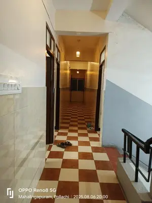 a hallway with a checkered floor in a building at Hotel BMR Stay in Pollāchi