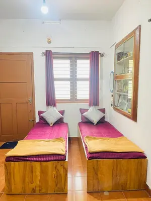 two beds in a room with purple curtains at Quiet quarters Estate Stay in Napoklu