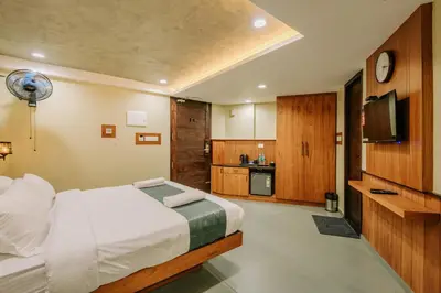 a bedroom with a bed and a television in it at Hotel Urban Bella in Kozhikode