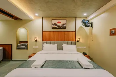 a bedroom with a large bed and a mirror at Hotel Urban Bella in Kozhikode
