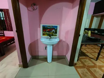 a bathroom with a white sink in a pink wall at Banasura Green paradise , Villa , Deluxe rooms , Budget rooms in Padinjarathara
