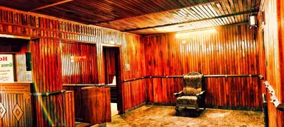 an empty room with wooden walls and a chair at Banasura Green paradise , Villa , Deluxe rooms , Budget rooms in Padinjarathara