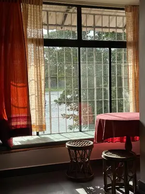 a window with a table and two stools in front of it at Pearl Spot in Alwaye
