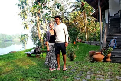 a man and a woman standing next to a house at Pearl Spot in Alwaye