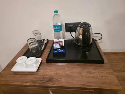 a table with a coffee maker and a tea kettle at Suraksha Suites in Mysore