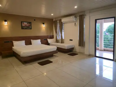 a bedroom with two beds and a window at Suraksha Suites in Mysore
