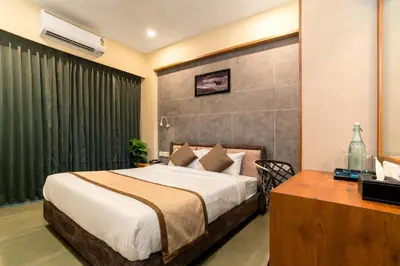 a hotel room with a bed and a desk at Neelagiri Heritage Hotel in Kozhikode
