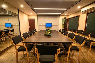 a conference room with a large wooden table and chairs at Neelagiri Heritage Hotel in Kozhikode