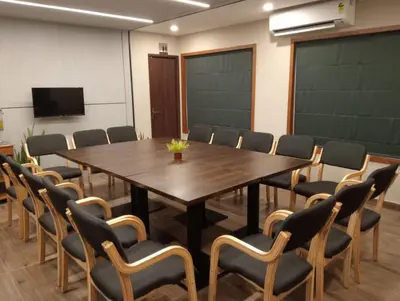 a conference room with a wooden table and chairs at Neelagiri Heritage Hotel in Kozhikode