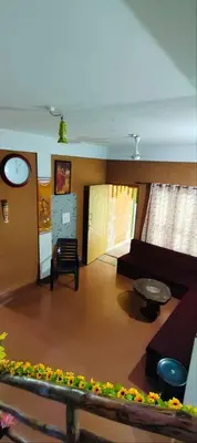 a living room with a couch and a table at Tejana villa in Mananthavady