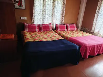 two beds sitting next to each other in a room at Tejana villa in Mananthavady
