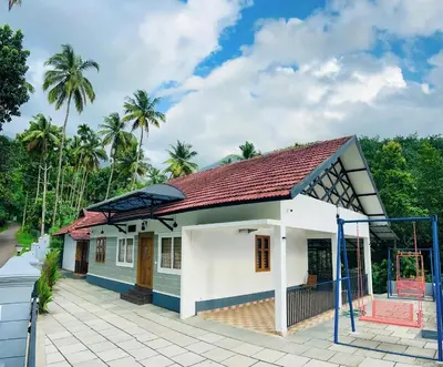 a small house with a red roof at Vayalil Homestay in Karuvārakundu